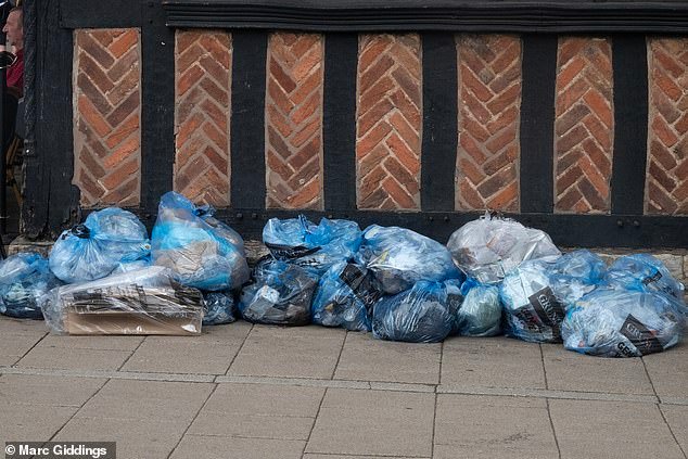Rubbish bags left by stores at the corner of the street when walking into Henley Street